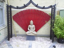 De stenen Boeddha in de achtertuin
